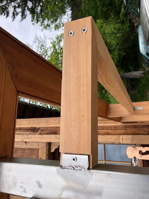 Detail einer Balkonstütze aus Naturholz